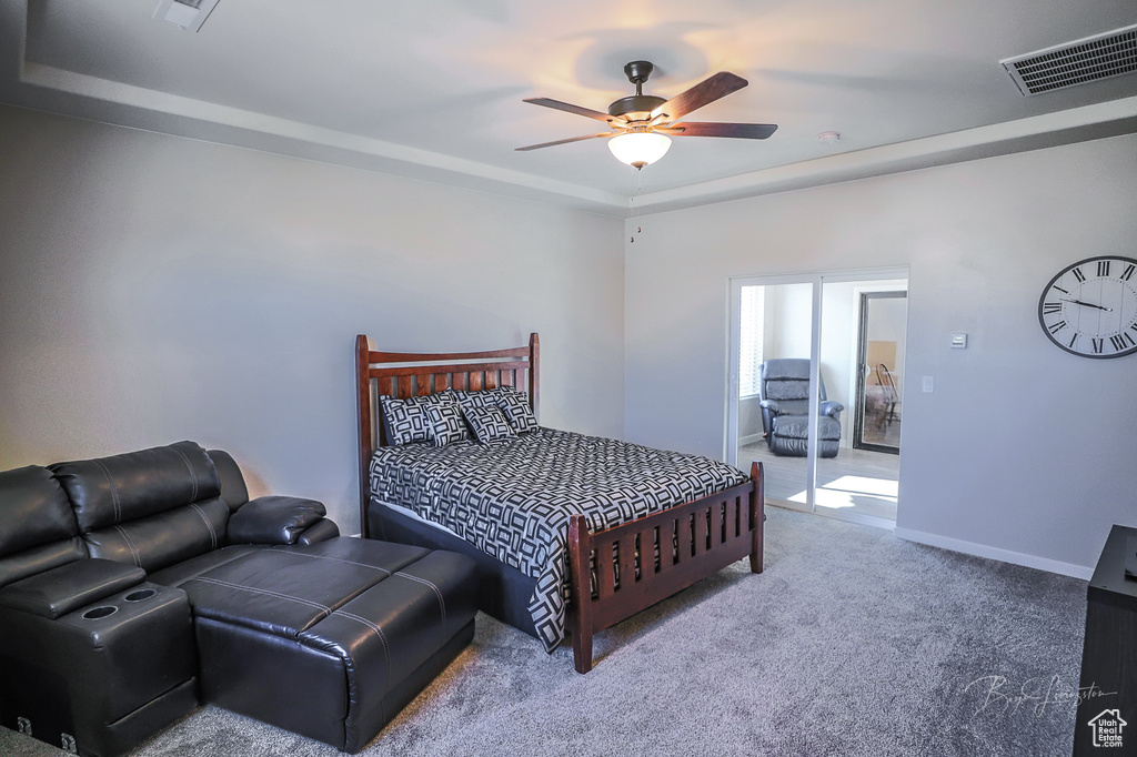 Bedroom featuring carpet, ceiling fan, and a tray ceiling