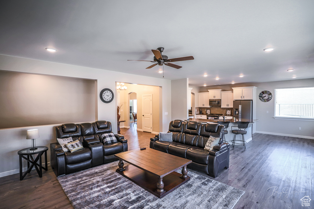 Living room with ceiling fan and dark hardwood / wood-style floors