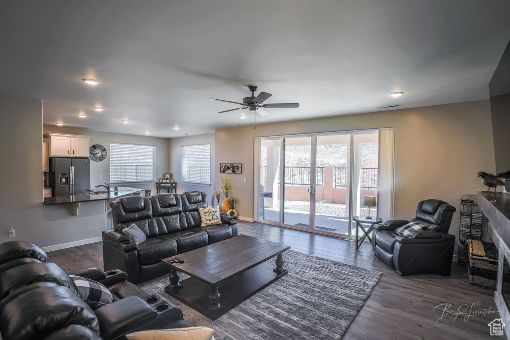Living room with dark hardwood / wood-style floors and ceiling fan