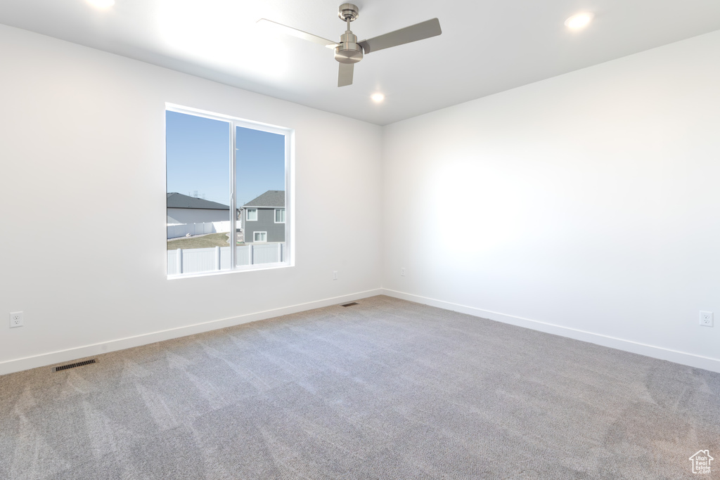 Carpeted spare room with ceiling fan