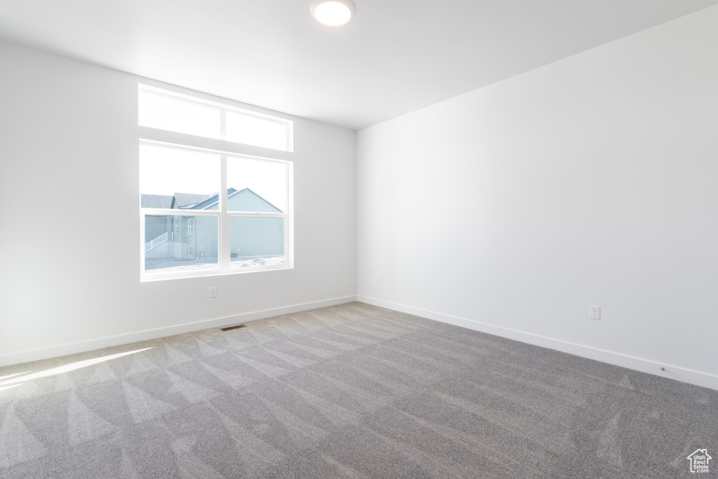 Empty room featuring light carpet
