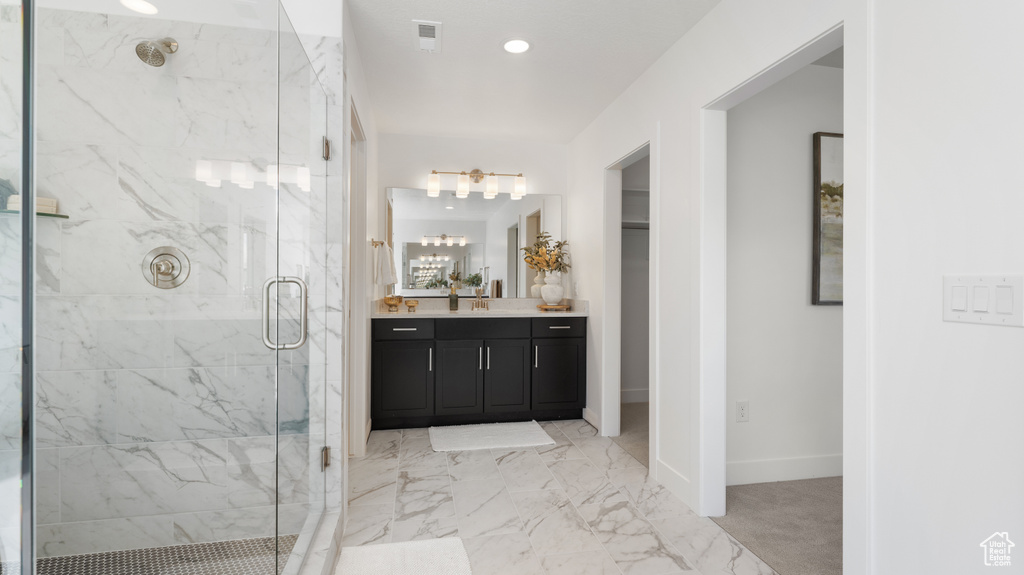 Bathroom with a marble finish shower, vanity, marble finish floors, baseboards, and recessed lighting
