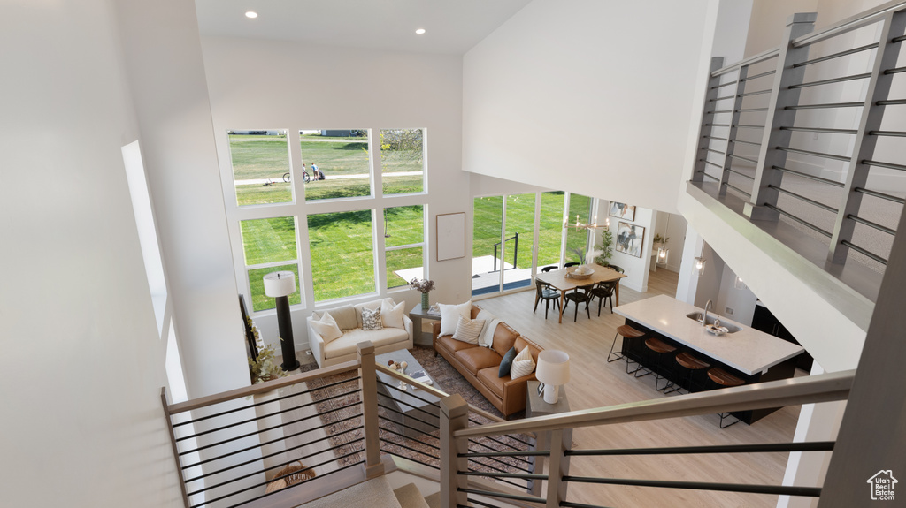 Living area with a high ceiling, recessed lighting, and wood finished floors