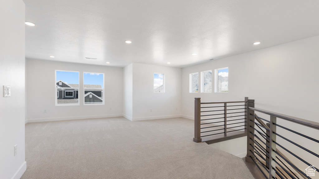 Carpeted spare room featuring healthy amount of natural light, recessed lighting, and baseboards
