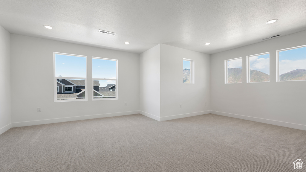 Spare room with light carpet, baseboards, and recessed lighting