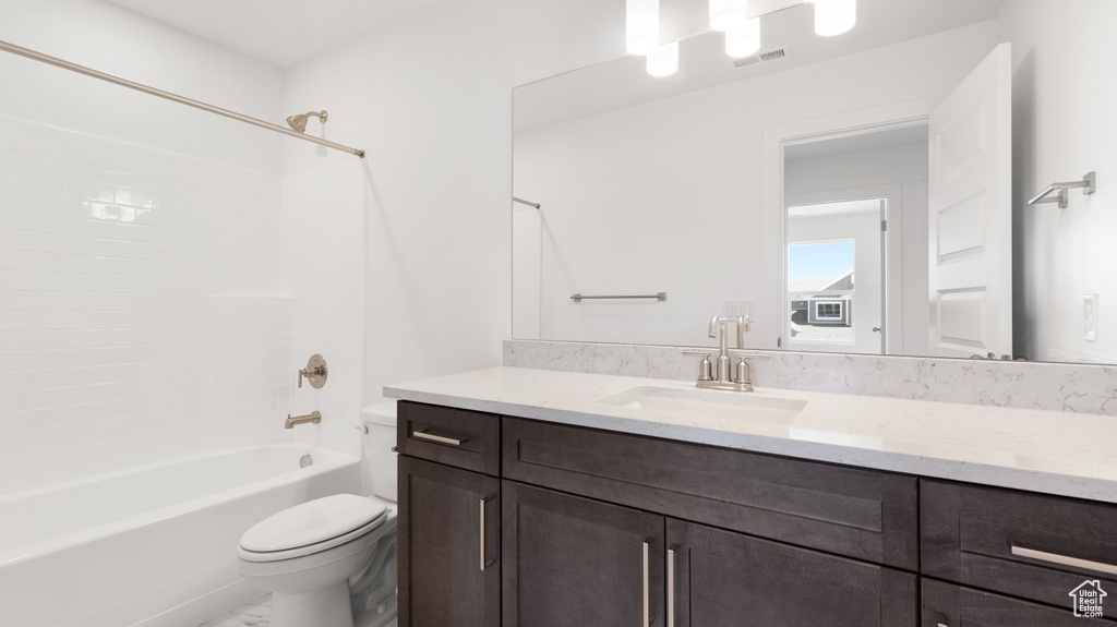 Bathroom featuring toilet, vanity, and shower / bath combination