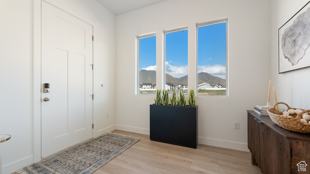 Entrance foyer with light wood-style flooring, baseboards, and a mountain view