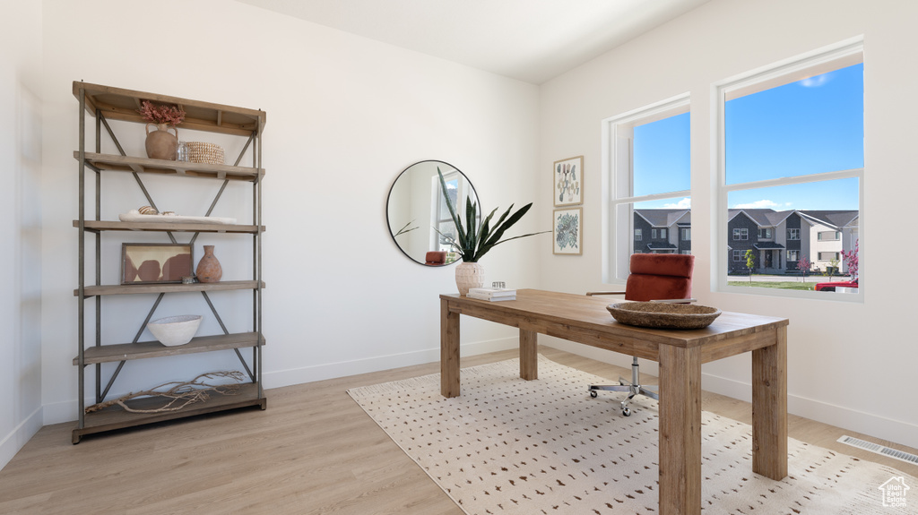 Home office with baseboards and light wood-style flooring