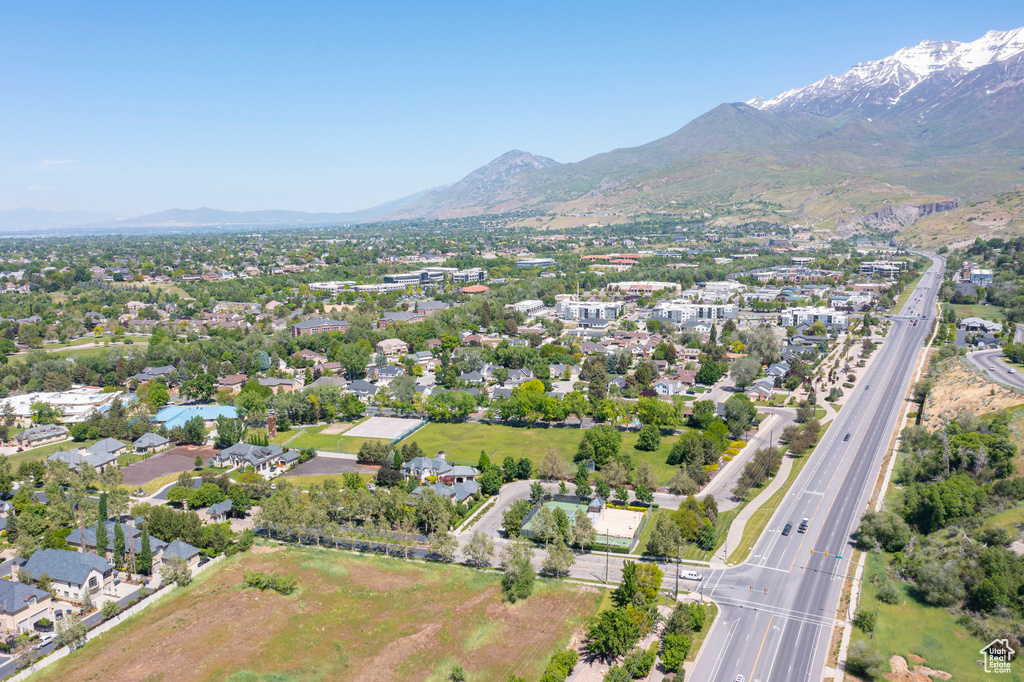 Aerial view of property and surrounding area featuring a mountainous background and a major roadway
