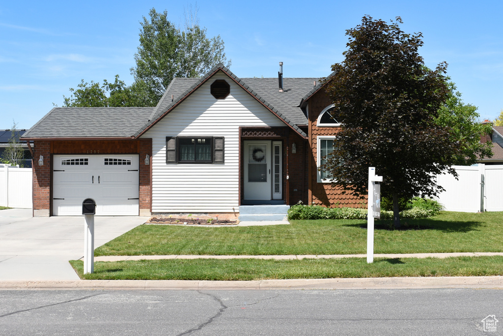View of front of house featuring a garage, driveway, and roof with shingles
