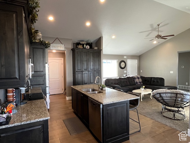 Kitchen with a sink, ceiling fan, a kitchen island with sink, vaulted ceiling, and stainless steel appliances