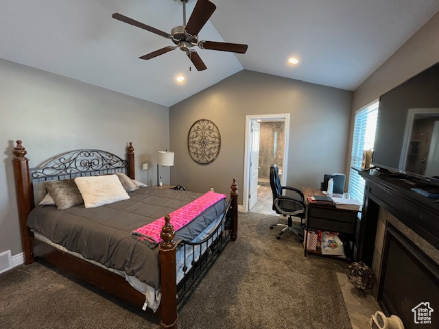Carpeted bedroom featuring lofted ceiling, baseboards, ensuite bathroom, visible vents, and ceiling fan