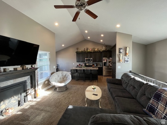 Living room featuring a fireplace, a ceiling fan, lofted ceiling, and recessed lighting
