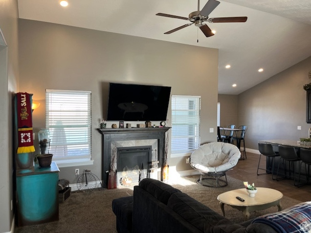 Living room with baseboards, vaulted ceiling, recessed lighting, ceiling fan, and a high end fireplace