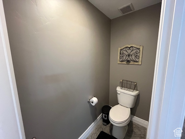 Bathroom featuring visible vents, baseboards, and toilet
