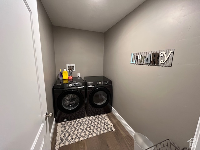 Laundry room featuring washer and dryer, laundry area, wood finished floors, and baseboards