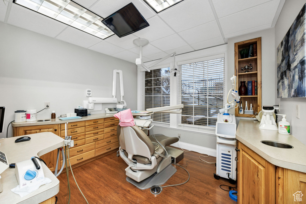 Office area featuring dark hardwood / wood-style flooring and a paneled ceiling