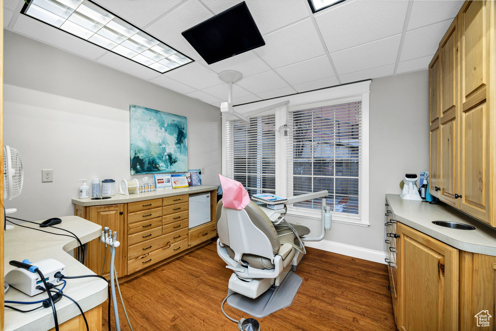 Office area featuring dark hardwood / wood-style floors and a drop ceiling