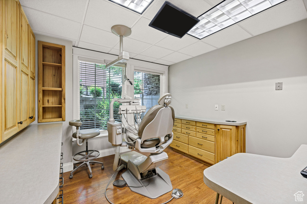 Office space featuring light wood finished floors and a paneled ceiling