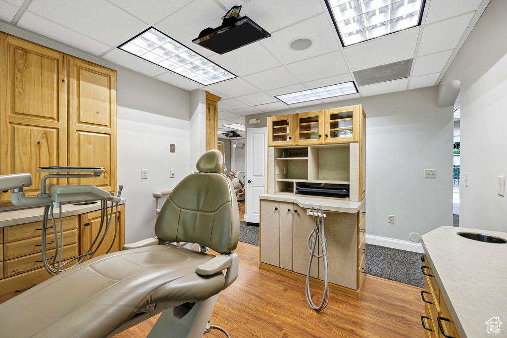 Home office with a paneled ceiling and light wood-type flooring
