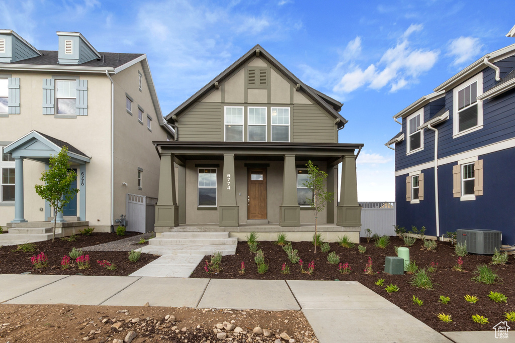 View of front of home featuring cooling unit, covered porch, and stucco siding