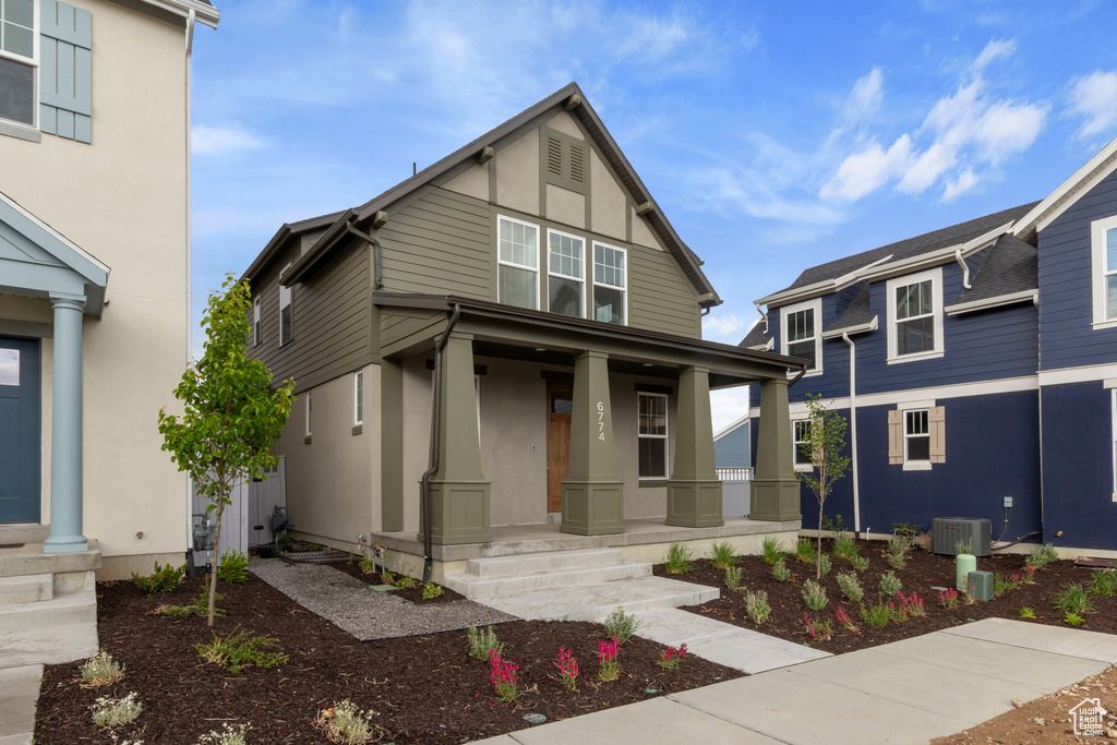 View of front of property featuring covered porch, stucco siding, and central air condition unit