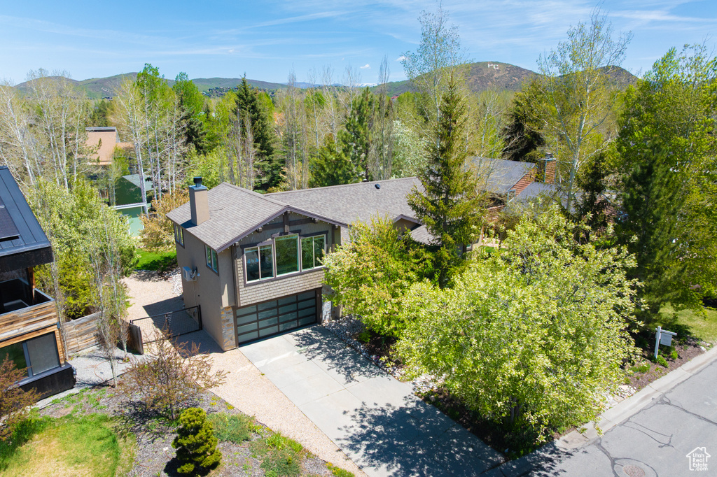 Aerial view of property and surrounding area featuring a mountain backdrop