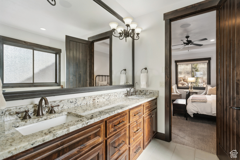 Bathroom featuring tile patterned floors, vanity, and ceiling fan with notable chandelier