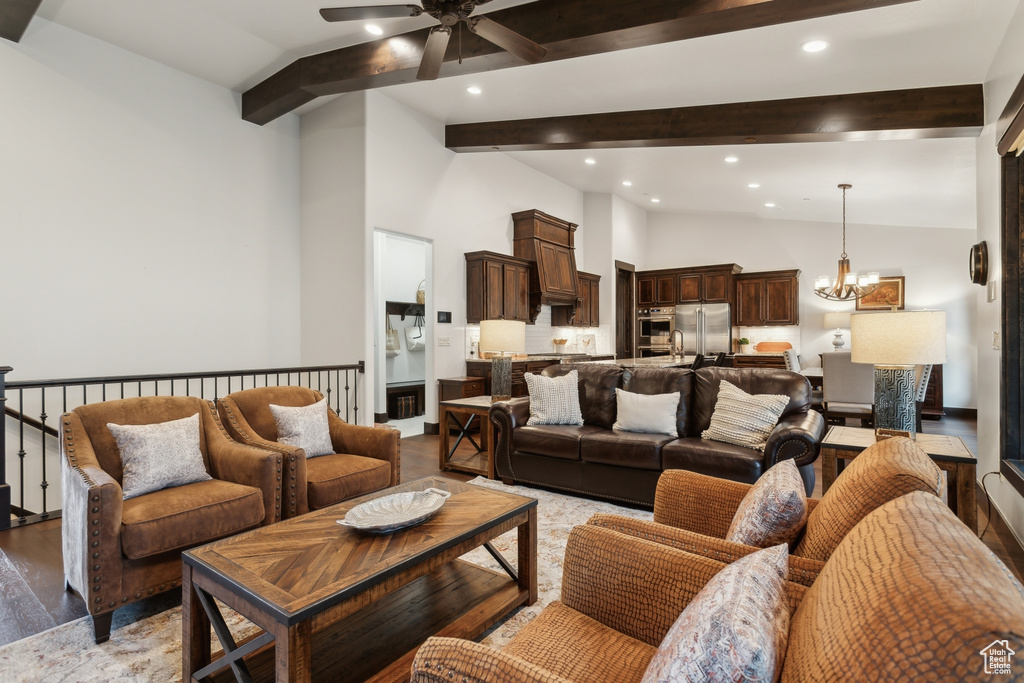 Living room featuring ceiling fan with notable chandelier, light hardwood / wood-style flooring, and lofted ceiling with beams