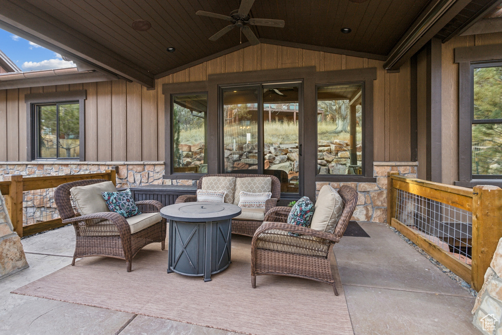 View of patio with an outdoor living space with a fire pit and ceiling fan