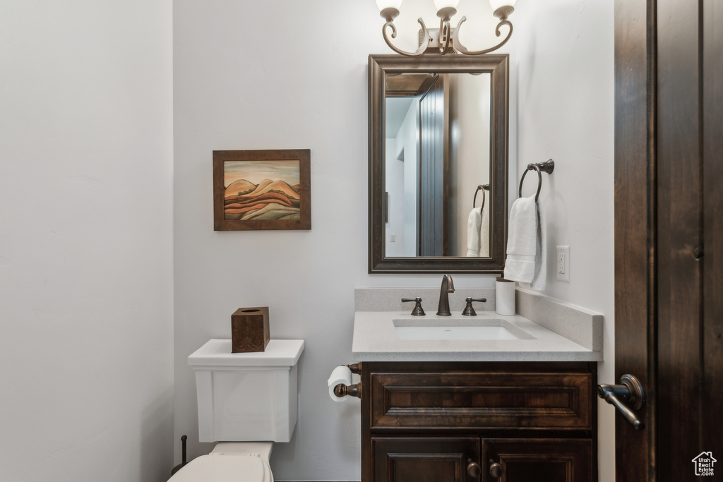 Bathroom featuring vanity, a chandelier, and toilet