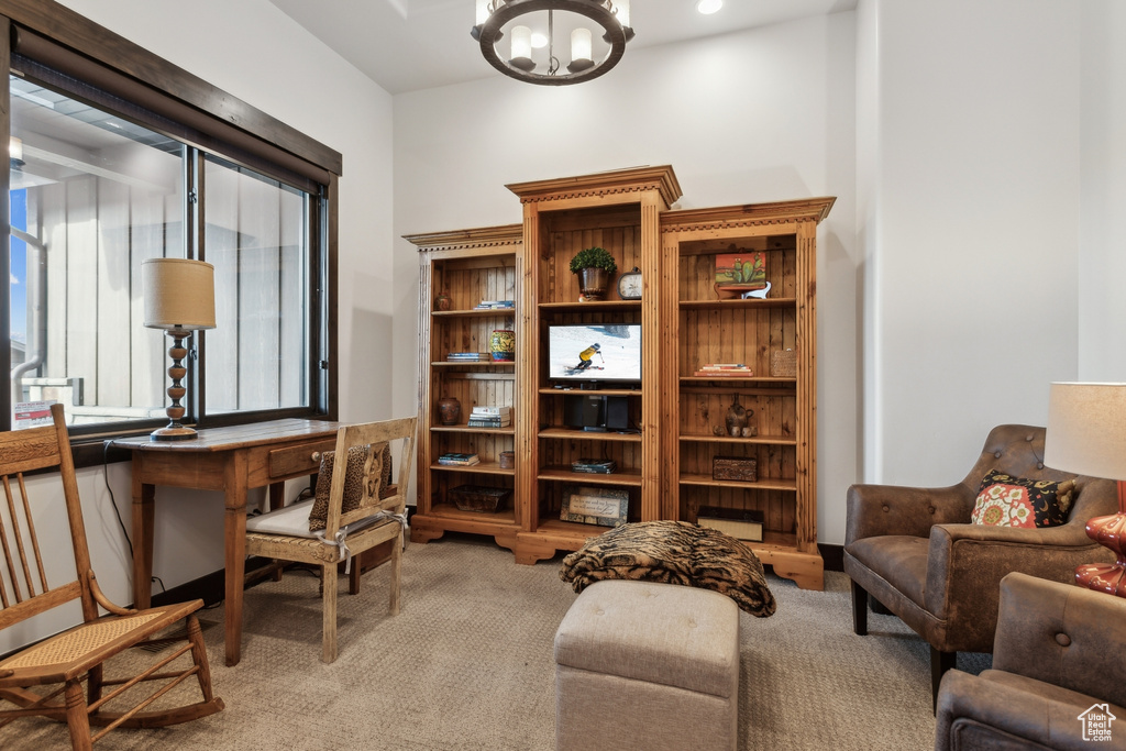 Office area with an inviting chandelier and light colored carpet