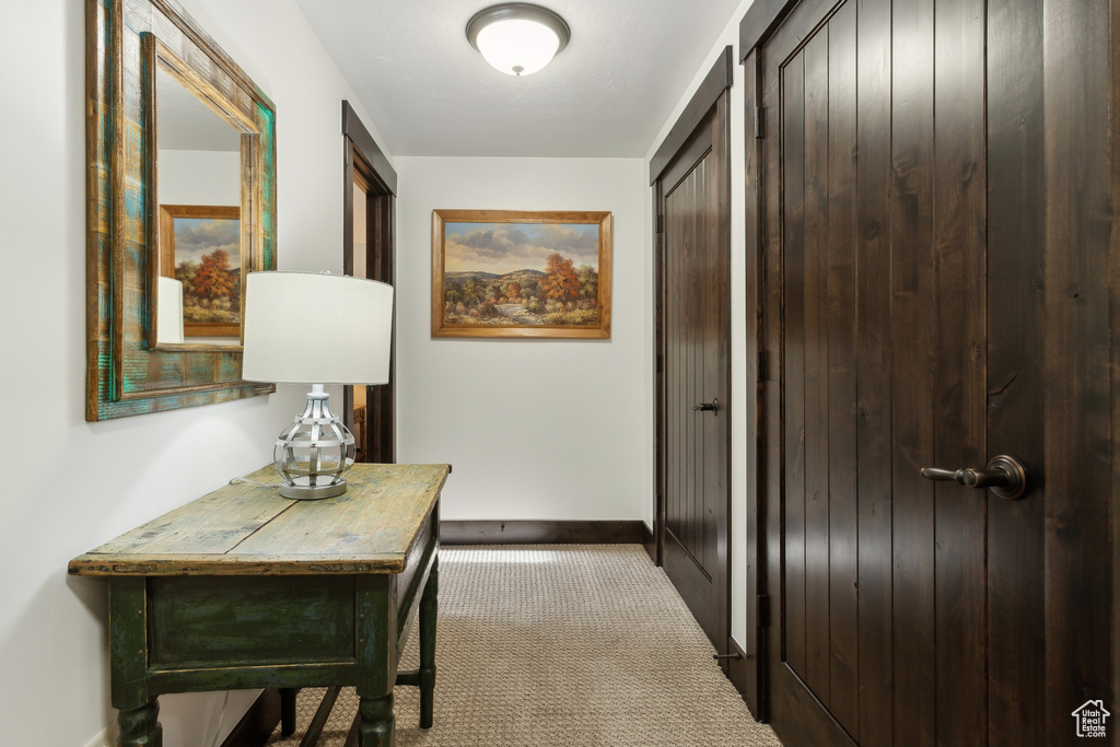 Hallway featuring light colored carpet