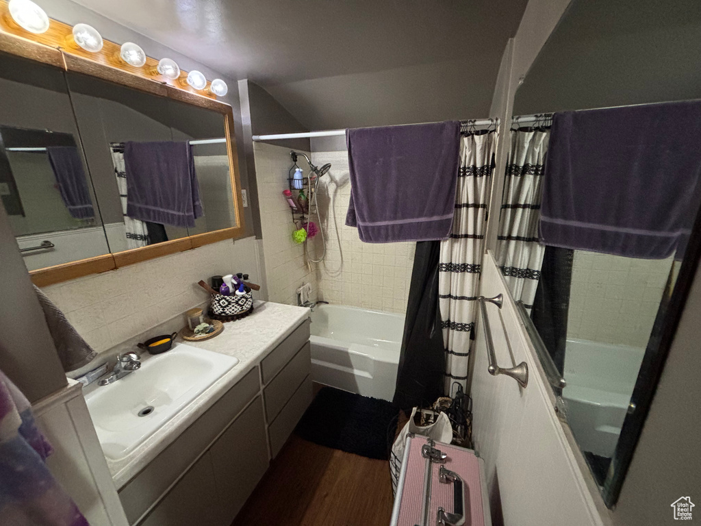 Bathroom featuring shower / tub combo with curtain, vanity, and hardwood / wood-style flooring