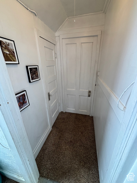 Hallway with carpet and lofted ceiling