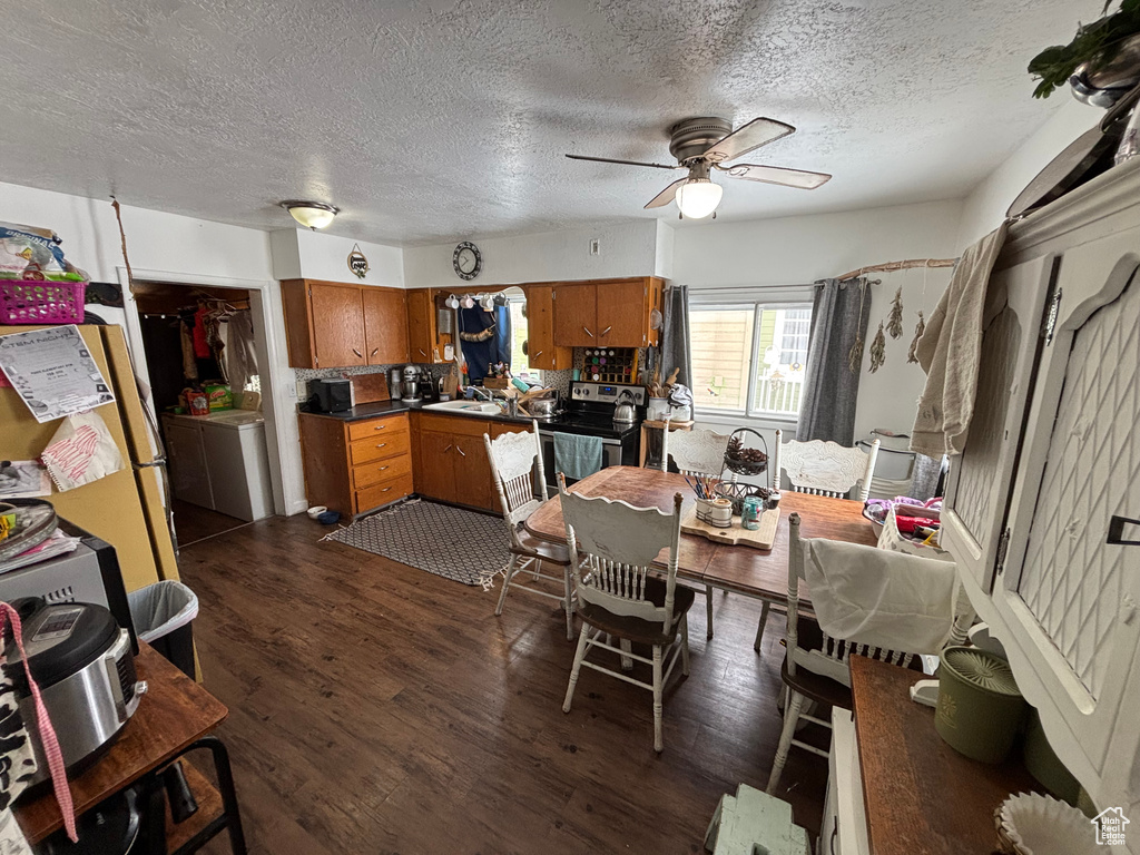 Dining area featuring sink, a textured ceiling, dark hardwood / wood-style floors, ceiling fan, and washer / clothes dryer
