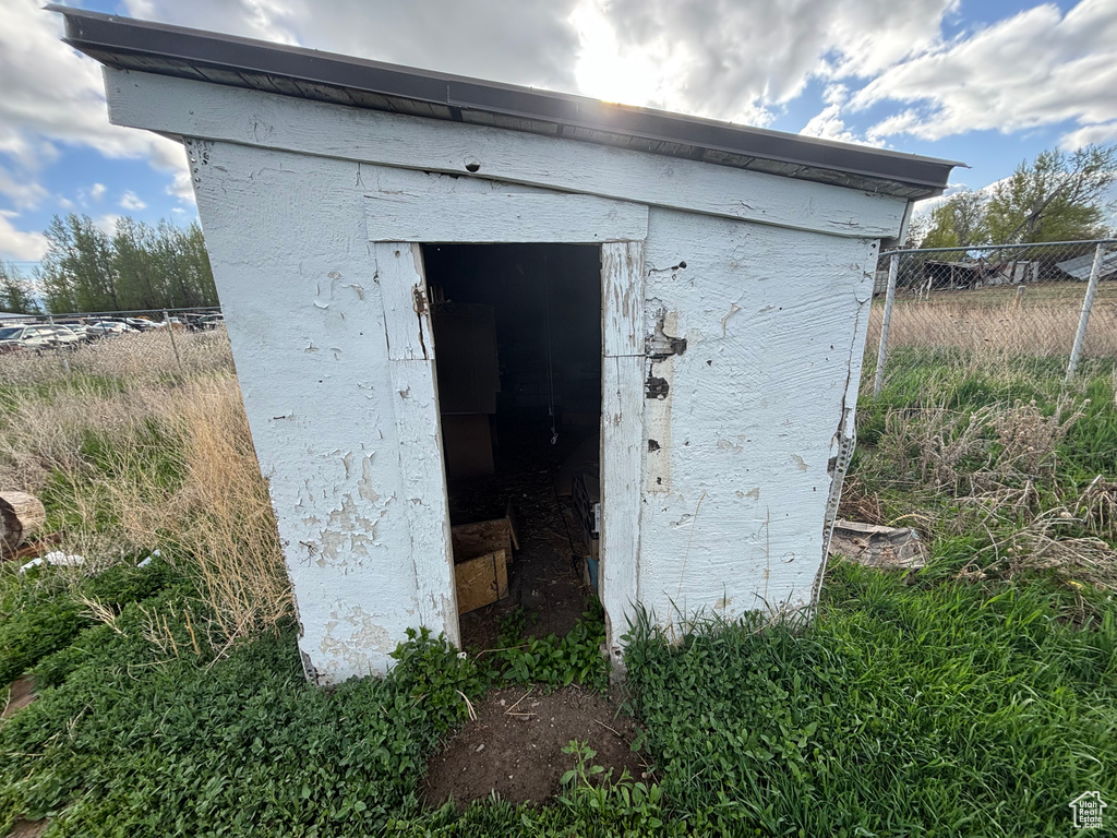 View of outbuilding featuring fence