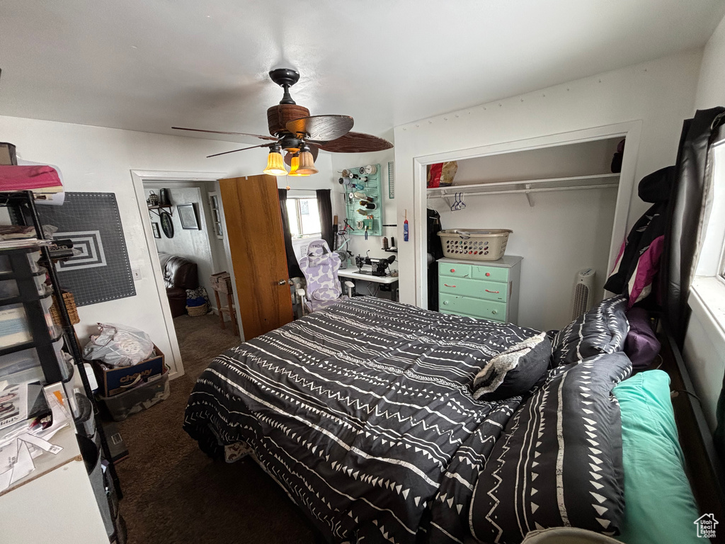 Carpeted bedroom featuring ceiling fan and a closet