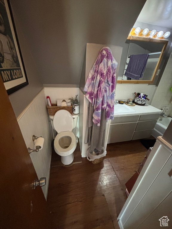 Bathroom with hardwood / wood-style flooring, vanity, and toilet