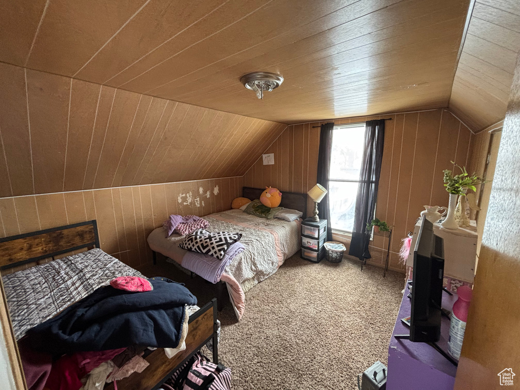 Bedroom featuring lofted ceiling, wooden ceiling, and wood walls