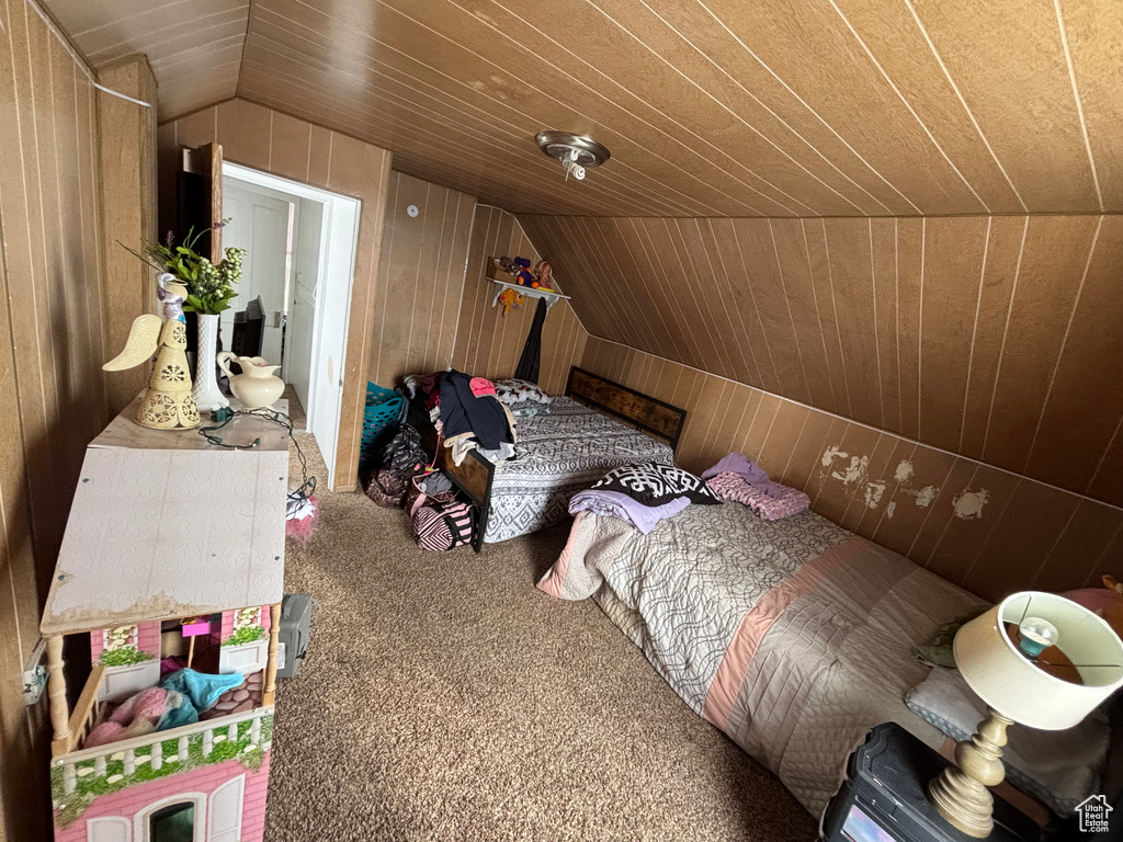 Bedroom with wood ceiling, carpet floors, vaulted ceiling, and wood walls