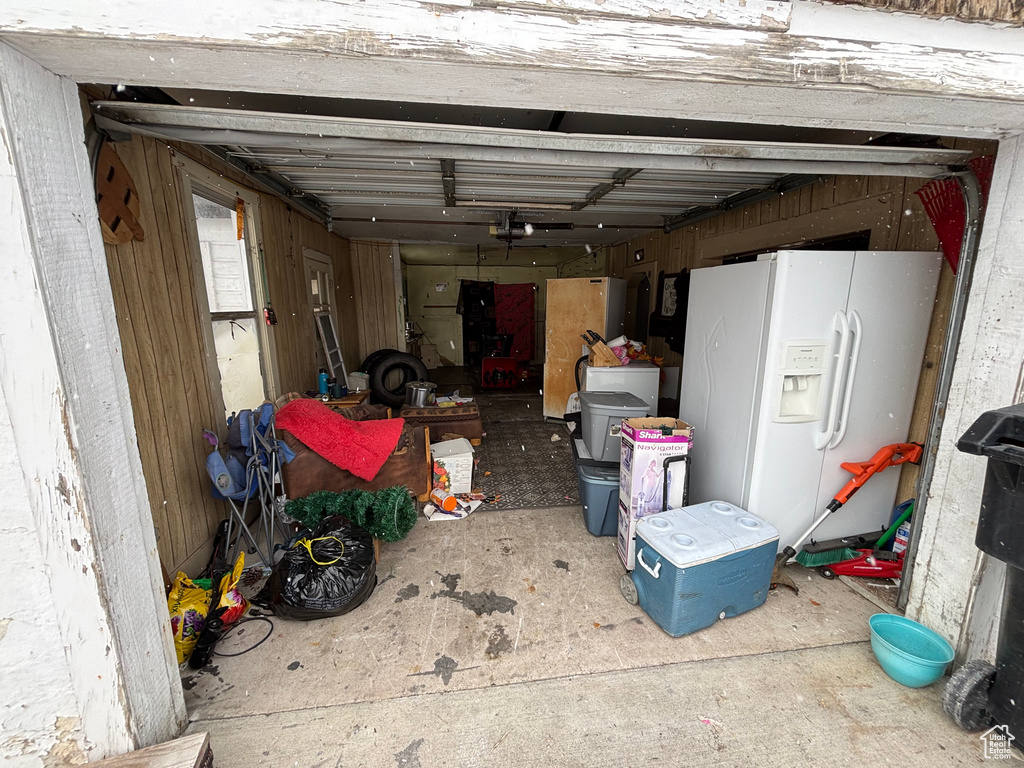 Garage with white refrigerator with ice dispenser and fridge