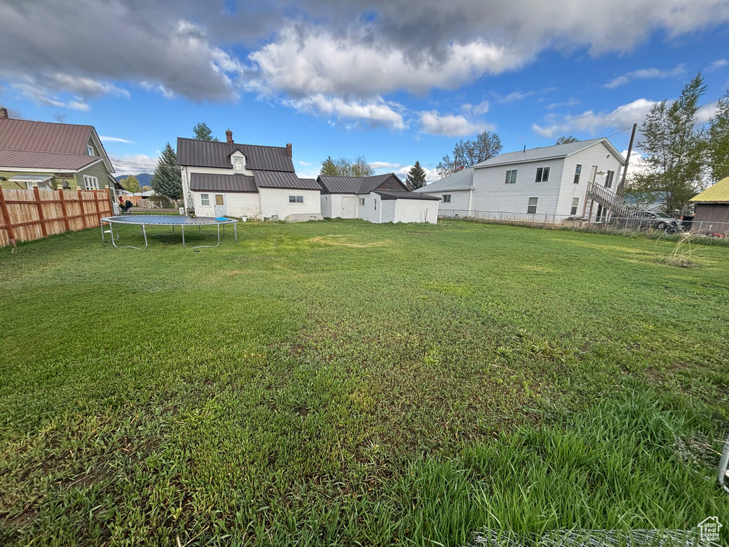 View of yard featuring a trampoline and a residential view