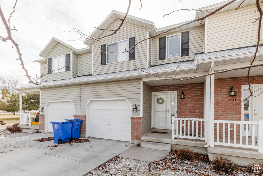 View of property with a garage and covered porch