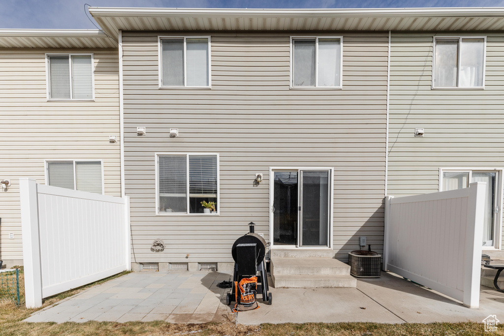 Back of property with a patio and central AC