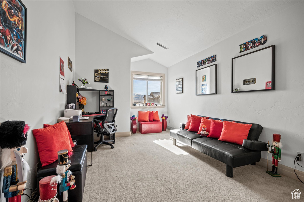 Home office with vaulted ceiling and carpet flooring