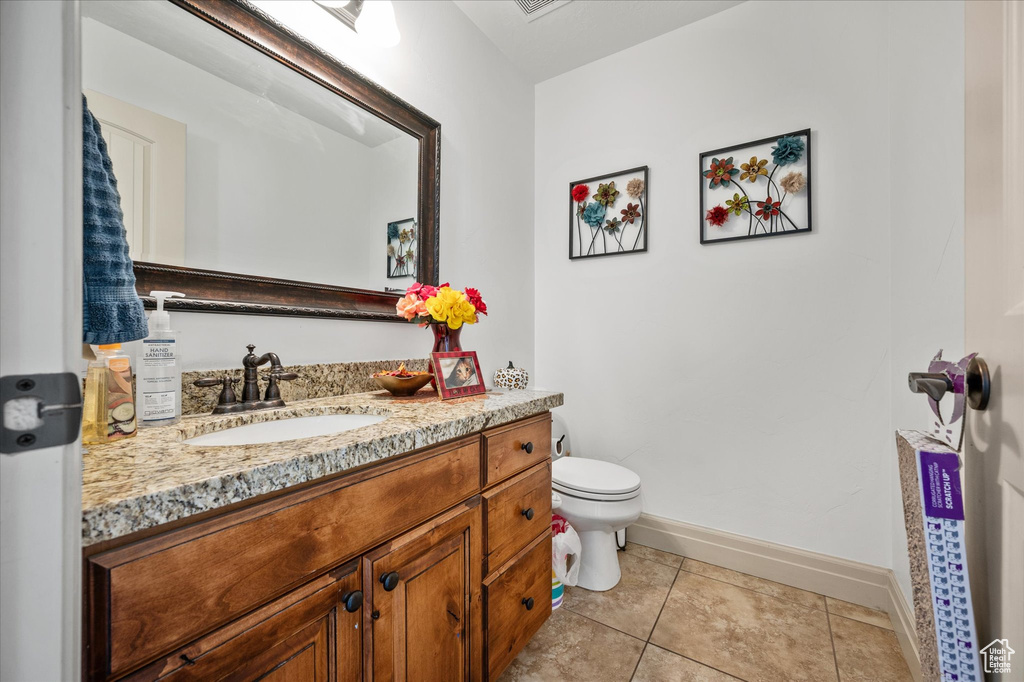 Bathroom with tile patterned flooring, vanity, and toilet