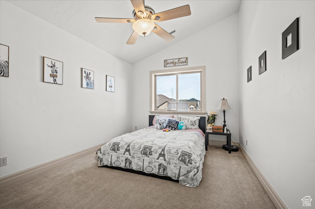 Bedroom with ceiling fan, vaulted ceiling, and carpet