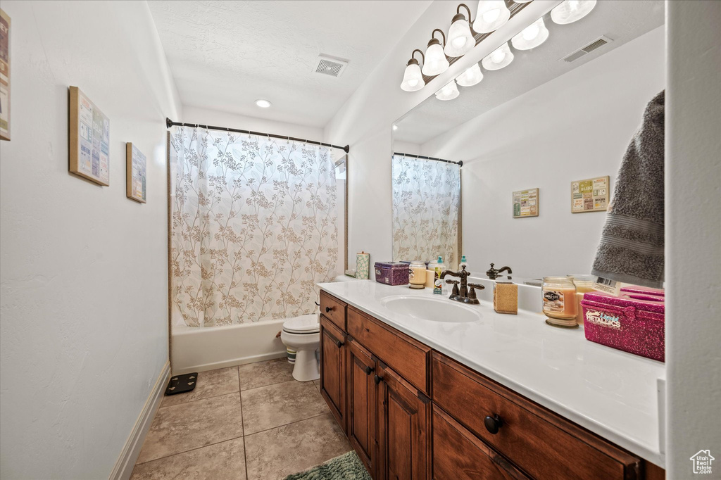 Full bathroom with vanity, shower / bath combo, tile patterned floors, and toilet