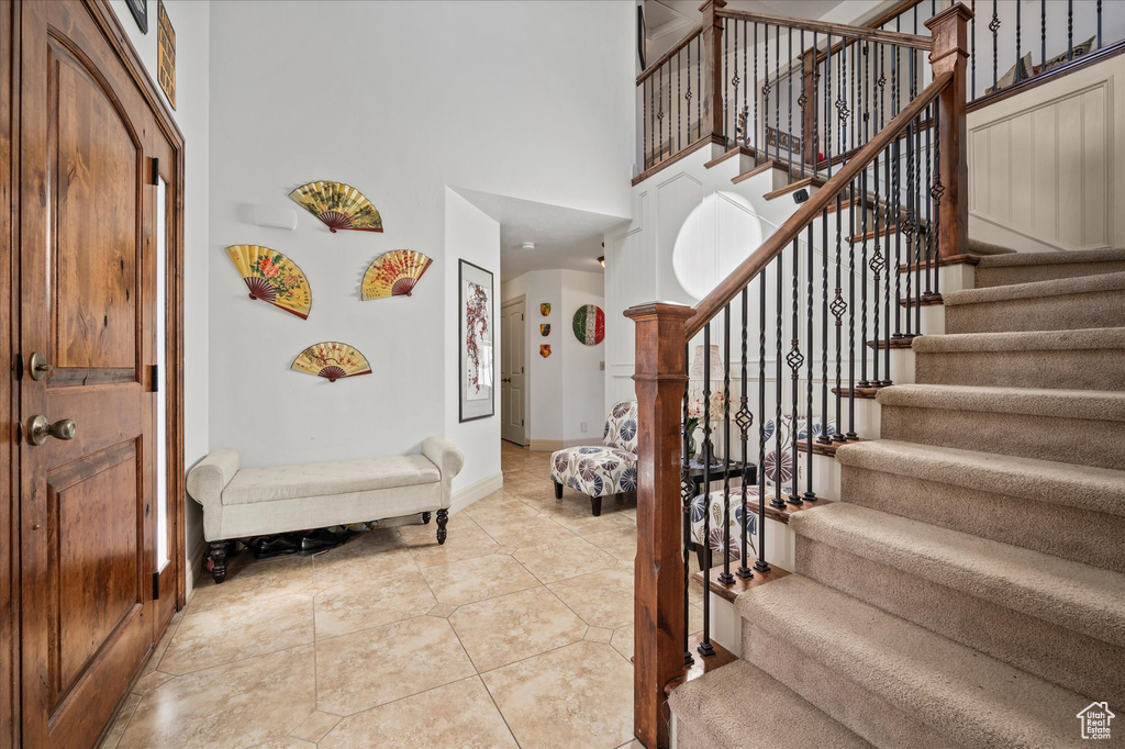 Foyer with light tile patterned floors and a high ceiling